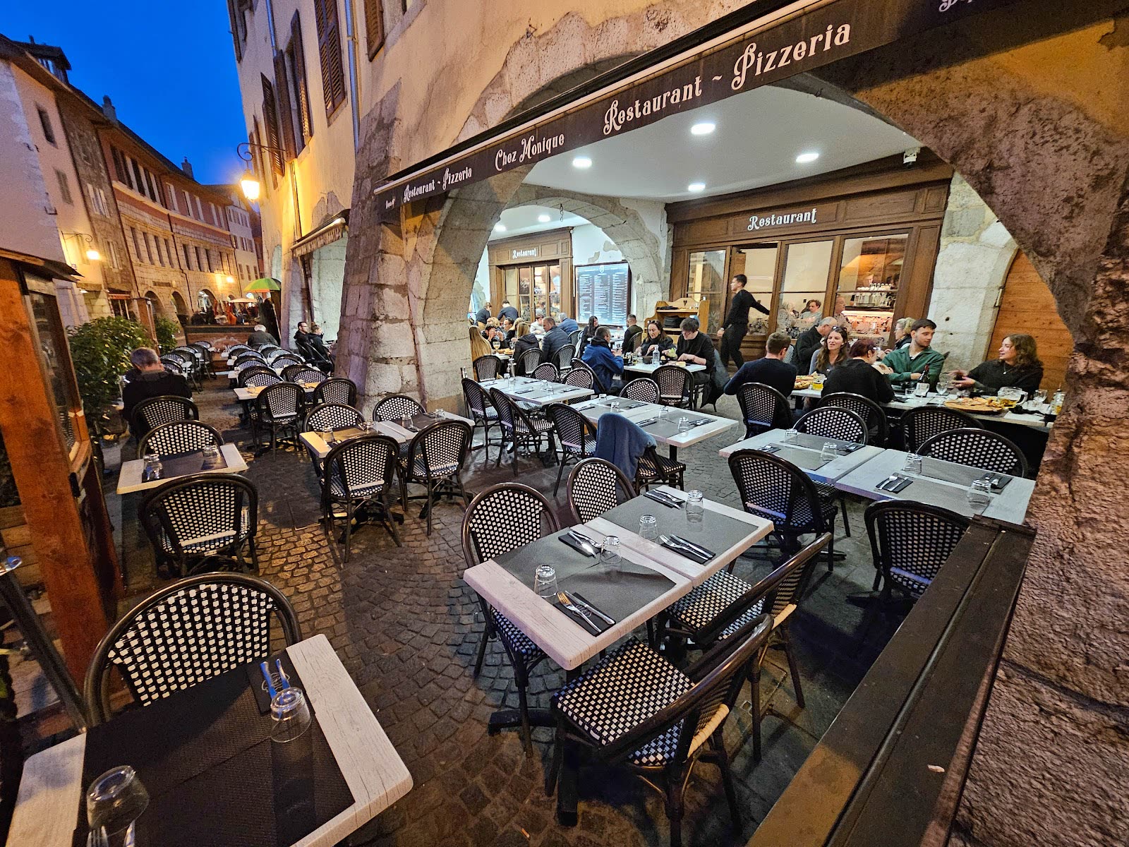 La terrasse de Chez Monique sous les arcades, à la tombée du soir